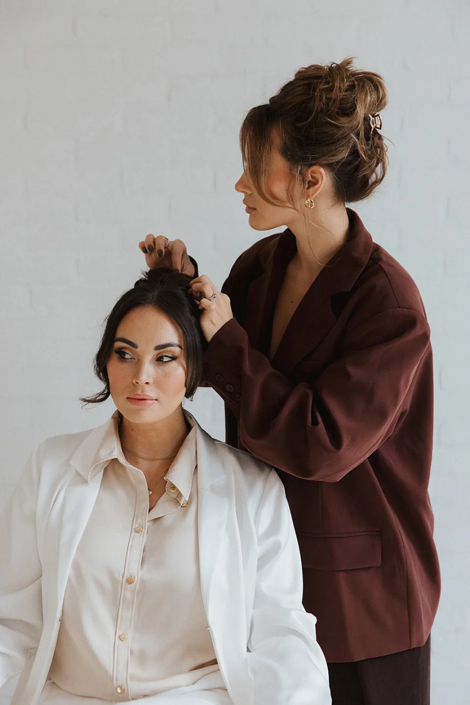 Stylist shaping a client's dark updo